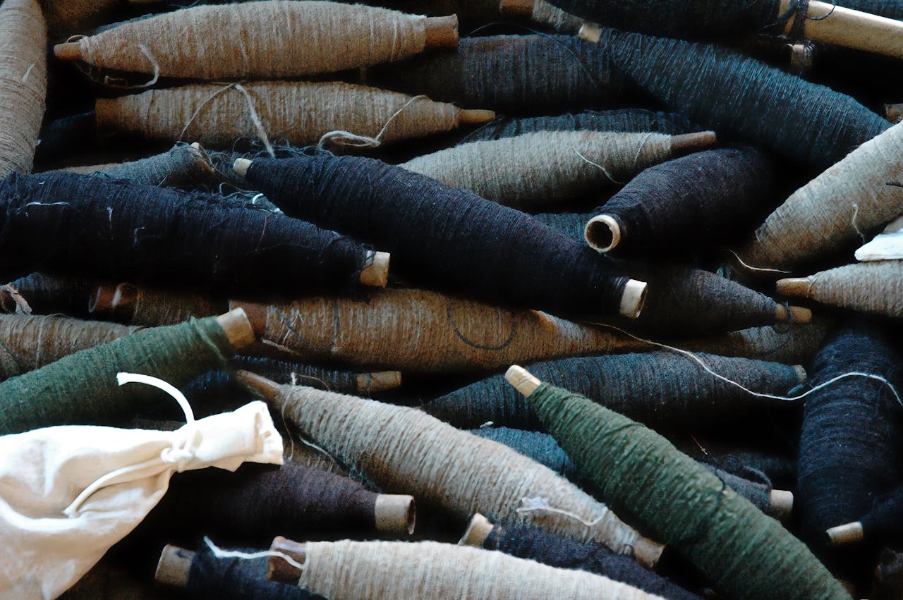 A diverse collection of thread spools, ideal for arts and crafts projects, showcasing different textures and colors.